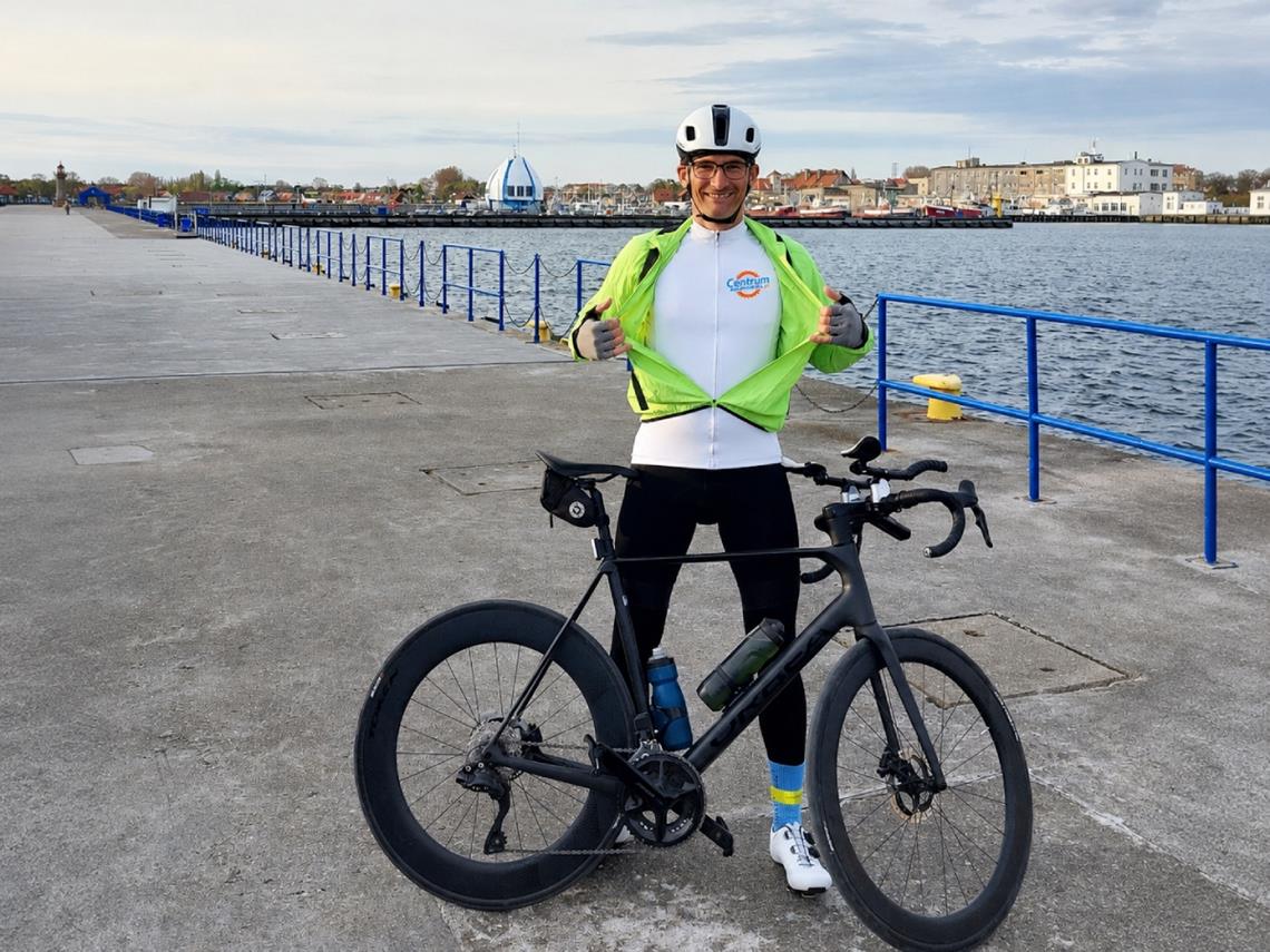 Jacek Kwiatkowski w koszulce centrum-rowerow.live, obok stoi rower