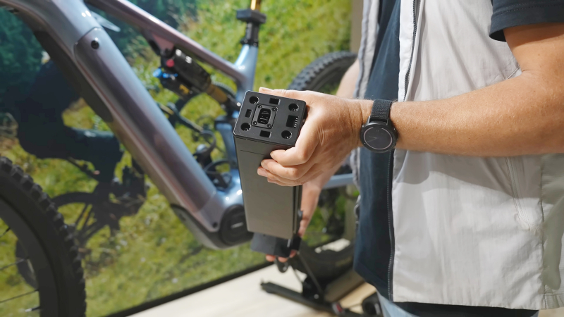 Rowerzysta trzymający baterię do roweru elektrycznego